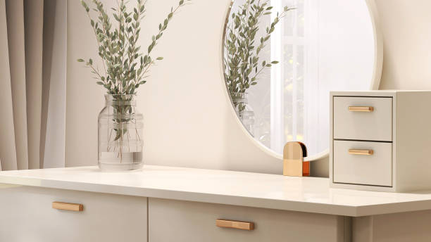 istock Empty modern, minimal beige dressing table, gold handle drawer storage, twig glass vase, round vanity mirror in cream wall bedroom in sunlight 1472056167