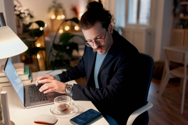 istock Businessman working on his laptop at home 1472057036