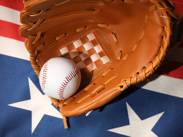 Baseball ball in a glove on the wooden table. USA flag. Baseball ball in a glove on the wooden table. USA flag. baseball free bet stock pictures, royalty-free photos & images