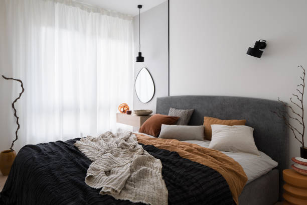 istock Cozy bed in modern bedroom with big window 1472058913