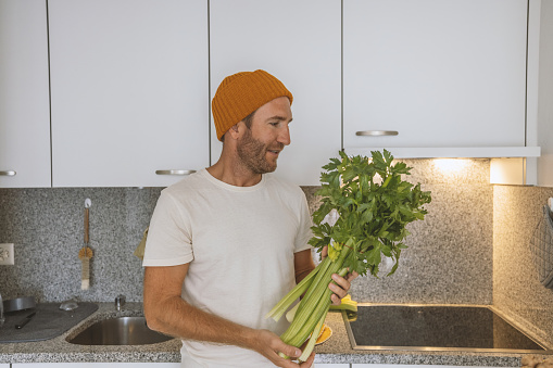 Portrait of man at home holding some vegetables