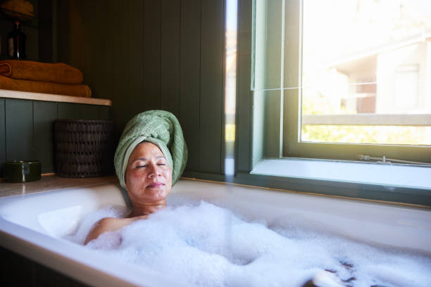 istock Mature woman lying in a bubble bath with her eyes closed 1472062389