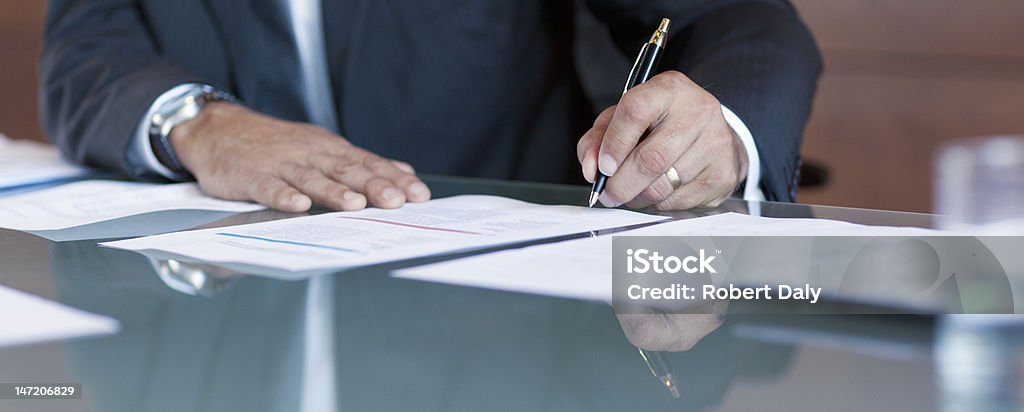 Businessman signing contract at table  Document Stock Photo