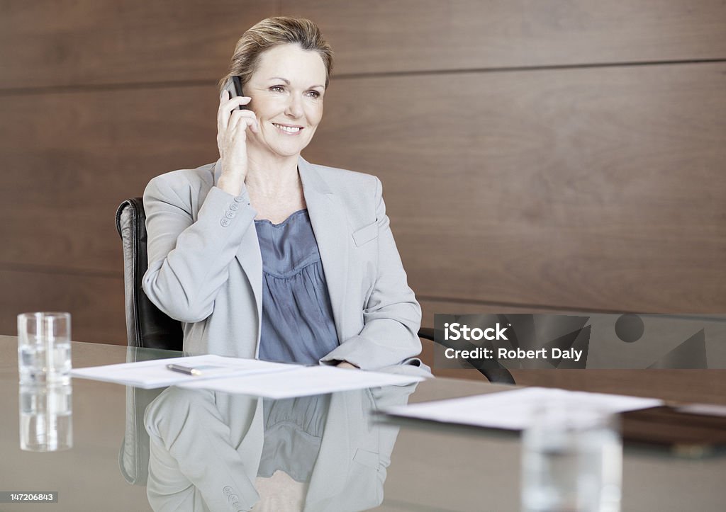 Sorridente Mulher de Negócios fala no telefone celular na Sala de Conferência - Royalty-free 60-64 anos Foto de stock