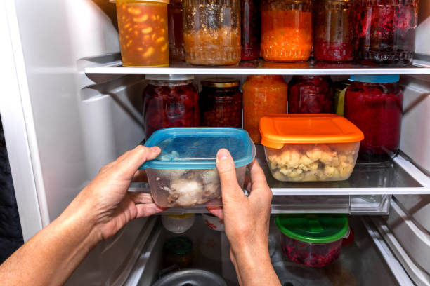 istock A woman puts packaged food in a home refrigerator 1472070654
