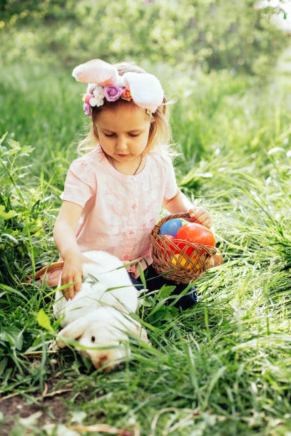 istock Baby with basket full of colorful eggs. Easter egg hunt. 1472070724