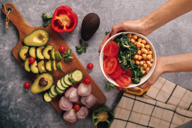 tazón de verduras sostenido por manos femeninas, vista aérea - antiinflamatorio fotografías e imágenes de stock