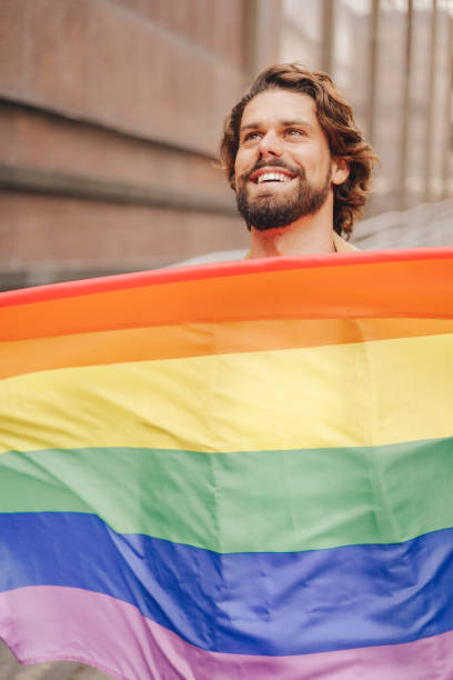 istock millennial man with lgbt flag, closeup view, good looking man 1472076769