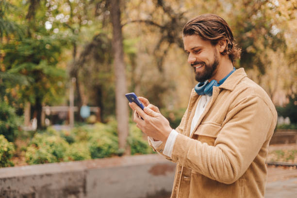 istock z gen caucasian man using cellphone in park 1472078440