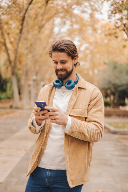 istock z gen caucasian man using cellphone in park 1472078522