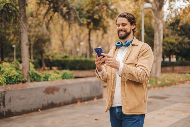 istock z gen caucasian man using cellphone in park 1472078559