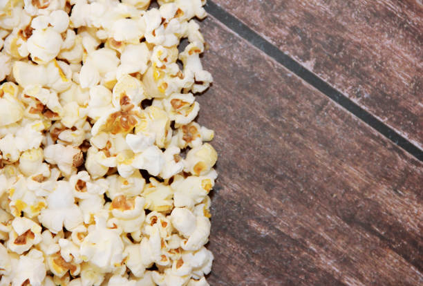 istock White fried popcorn on a brown wooden background 1472079839