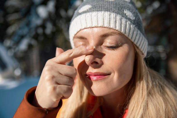 istock Smiling female applying sun protect  tone cream on nose 1472082874
