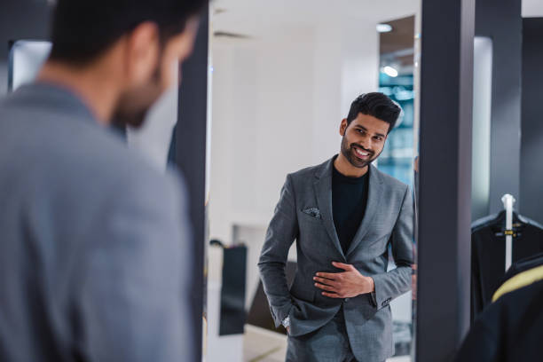 istock Young man shopping in clothing store 1472087402