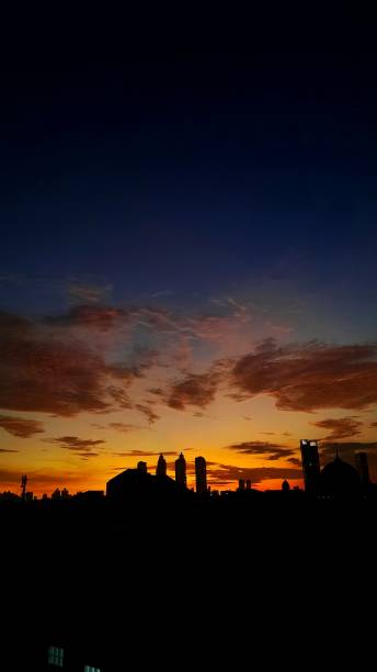 istock Beautiful city silhouette with dramatic colour in sky during cloudy sunset 1472090860