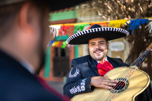 istock Young man traditional mariachi talking outdoors 1472091055