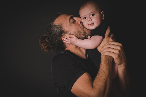 Father and Son over black background