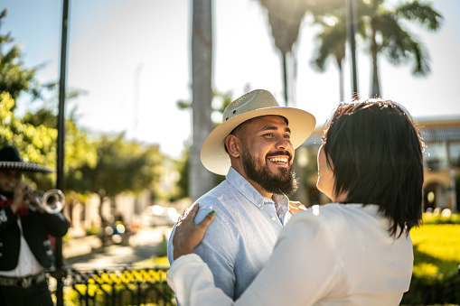 Couple dancing listening mariachi music outdoors