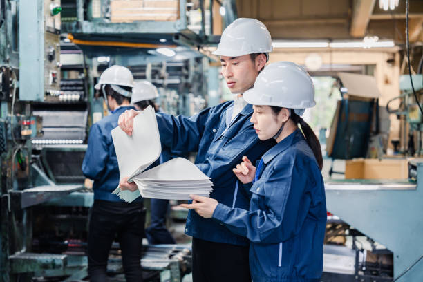 istock Factory staff checking a large amount of paper documents 1472099933