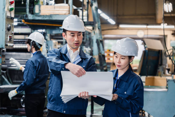 istock Factory staff checking a large amount of paper documents 1472099939
