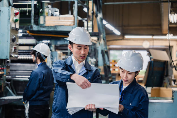 istock Factory staff checking a large amount of paper documents 1472099940