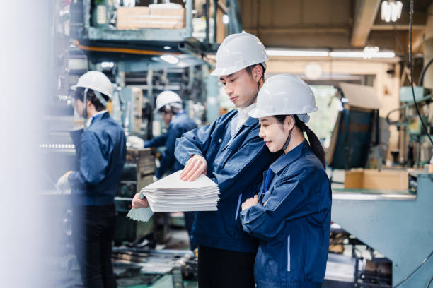 istock Factory staff checking a large amount of paper documents 1472099941