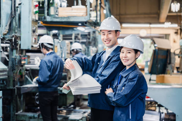 istock Factory staff checking a large amount of paper documents 1472099947