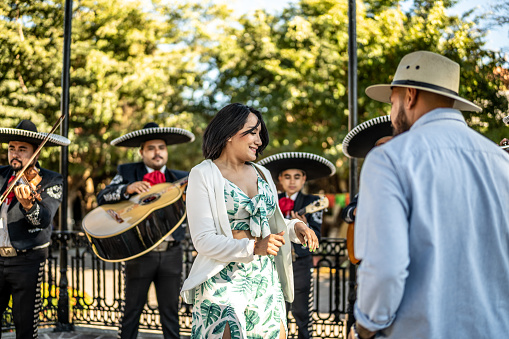 Couple dancing listening mariachi music outdoors