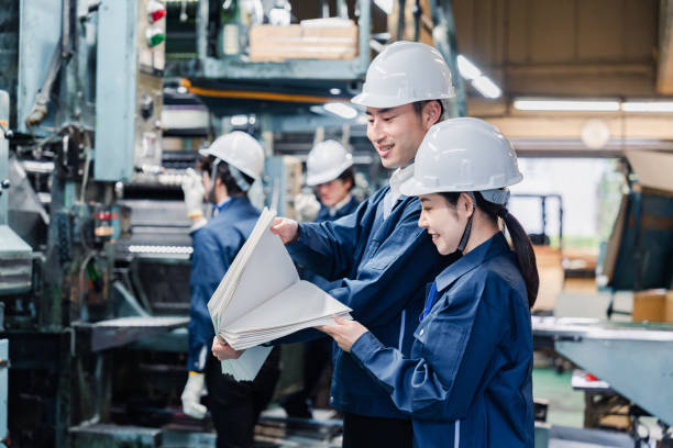 istock Factory staff checking a large amount of paper documents 1472099956