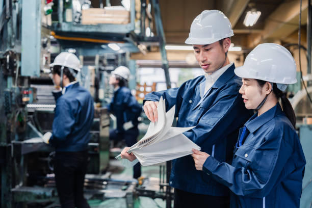 istock Factory staff checking a large amount of paper documents 1472099961