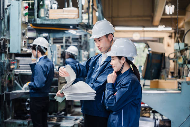istock Factory staff checking a large amount of paper documents 1472099976