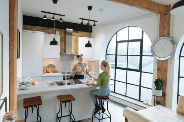istock Two friends preparing dinner at home and laughing 1472100232