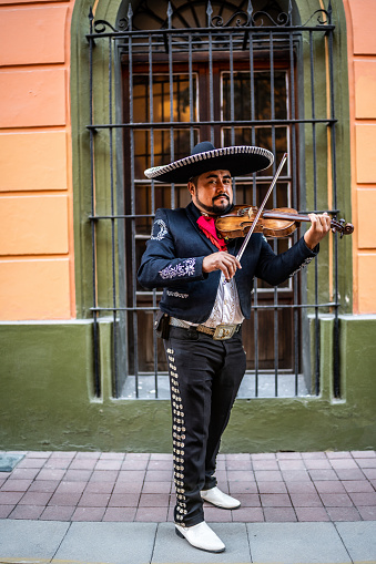 Portrait of mariachi violinist playing the violin at the historic district
