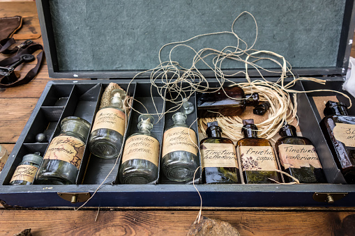 An old wooden box with medicines in glass bottles. Antique bottles have inscriptions in Latin.