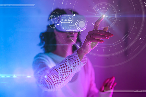 Woman's finger touching hologram of circles on digital virtual screen in neon pink and blue space