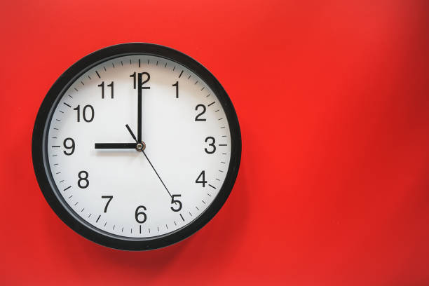 istock Classic black and white analog clock on red background at Nine o'clock with copy space 1472105712