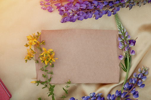 Craft paper mock up. Lupins purple flowers decorations. Natural, wellness closeness to nature. Summer invitation, birthday card, Mother's day concept. Feminine background.