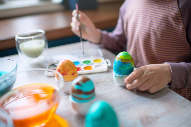 istock Cute little boy  painting Easter egg at home in springtime 1472107367