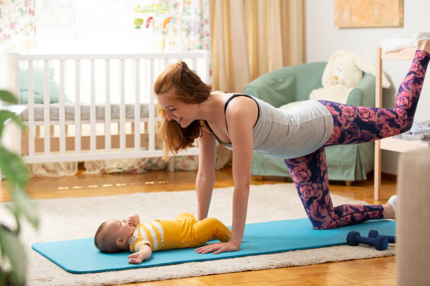 istock Young mother working out at home on a mat with baby 1472107679