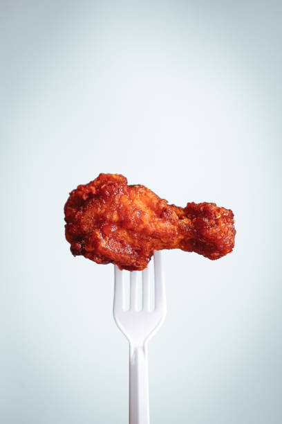 istock fried chicken on plastic fork with grey background, fast food Concept with copy space. 1472107911