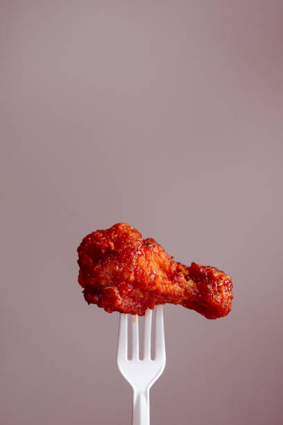 istock fried chicken on plastic fork with grey background, fast food Concept with copy space. 1472107916