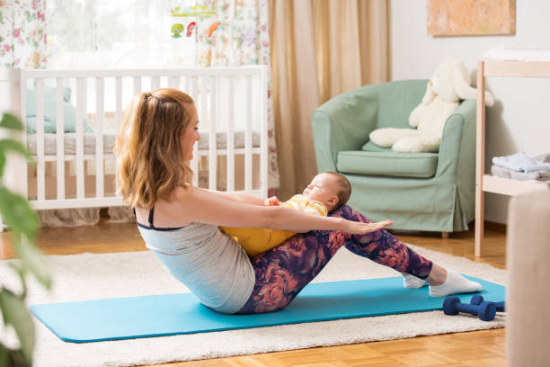 istock Young mother working out at home on a mat with baby 1472107940