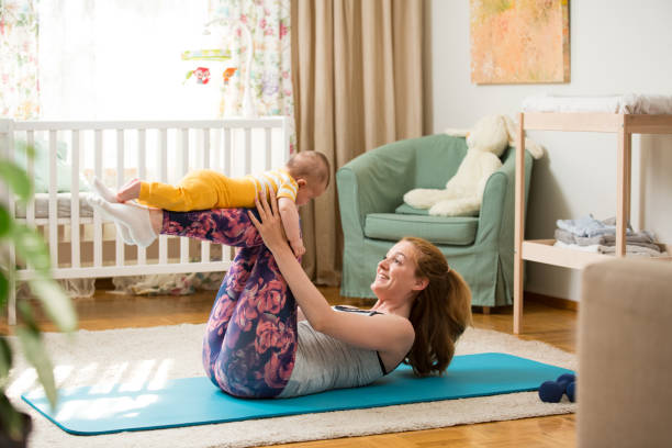 istock Young mother working out at home on a mat with baby 1472108003