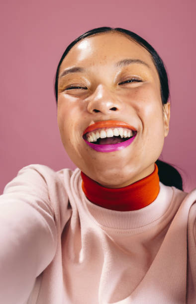 istock Happy selfie with two toned lips, woman taking a self-portrait in a studio 1472110419
