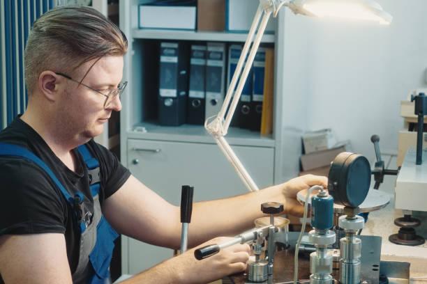 professional calibration of pressure gauges and sensors. working person sits at desk and is engaged in verification of instrumentation. - pressure gauge audio imagens e fotografias de stock