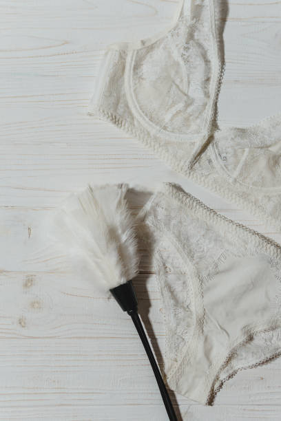 istock White lace bra on wooden background, closeup 1472112558