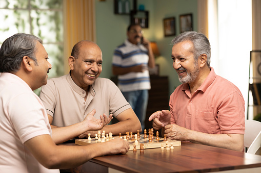 Senior people playing chess at home