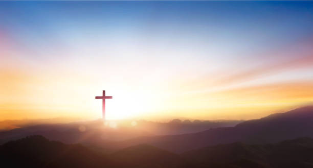 Silhouette of crucifix cross on mountain at sunset sky background. stock photo