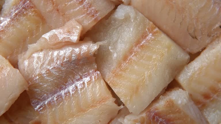 Raw fish fillet is spinning. Top view. Slices of fresh whitefish. Full frame. Sashimi rotation. Close up. Marine market. Video for sale. Cod, pollock loin steaks. Pangasius, tilapia pieces background.