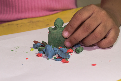 Children's hands playing with plasticine.